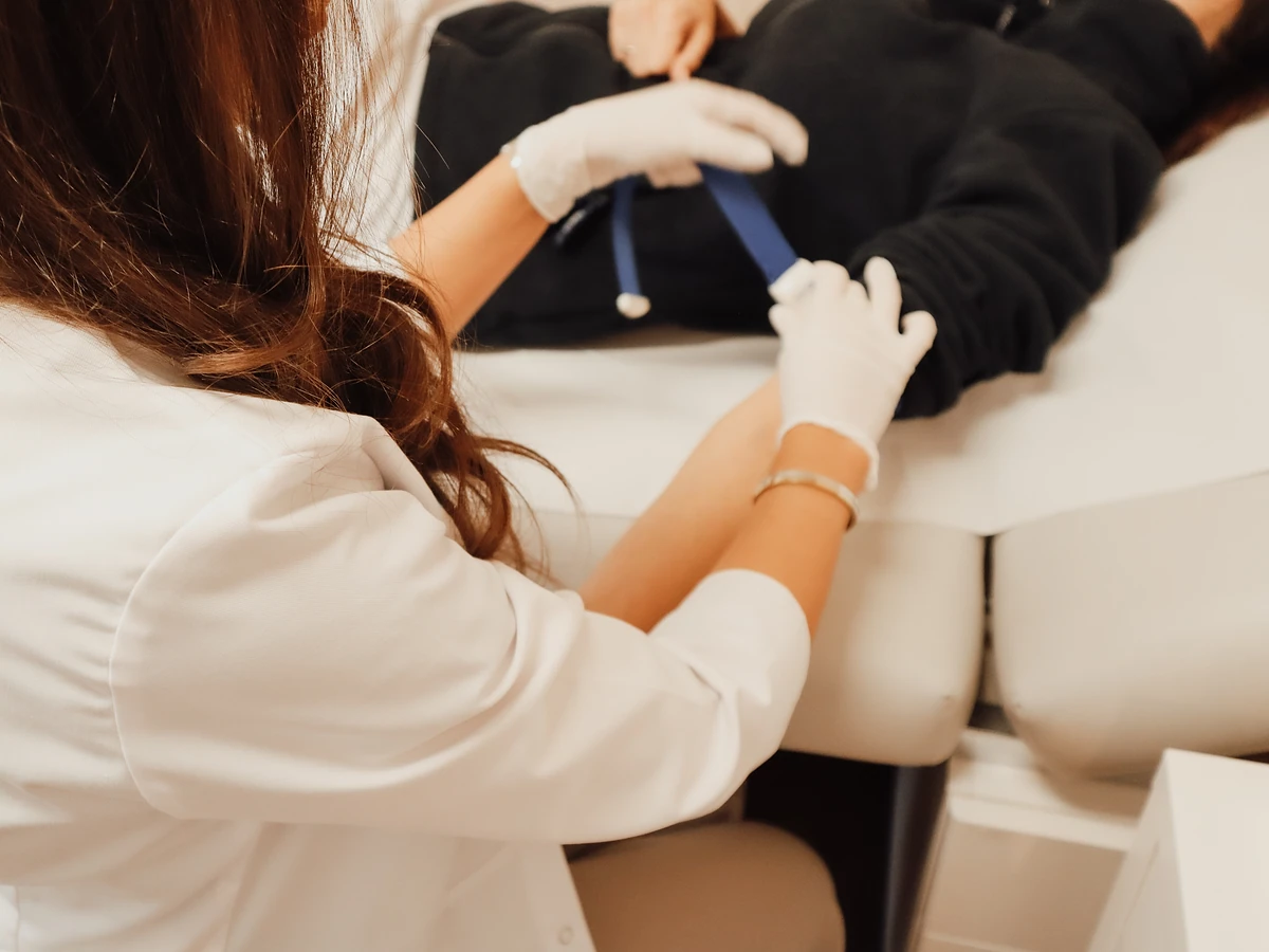 Im Cell Spa wird der Zugang für eine Infusion am Arm der Patientin gelegt